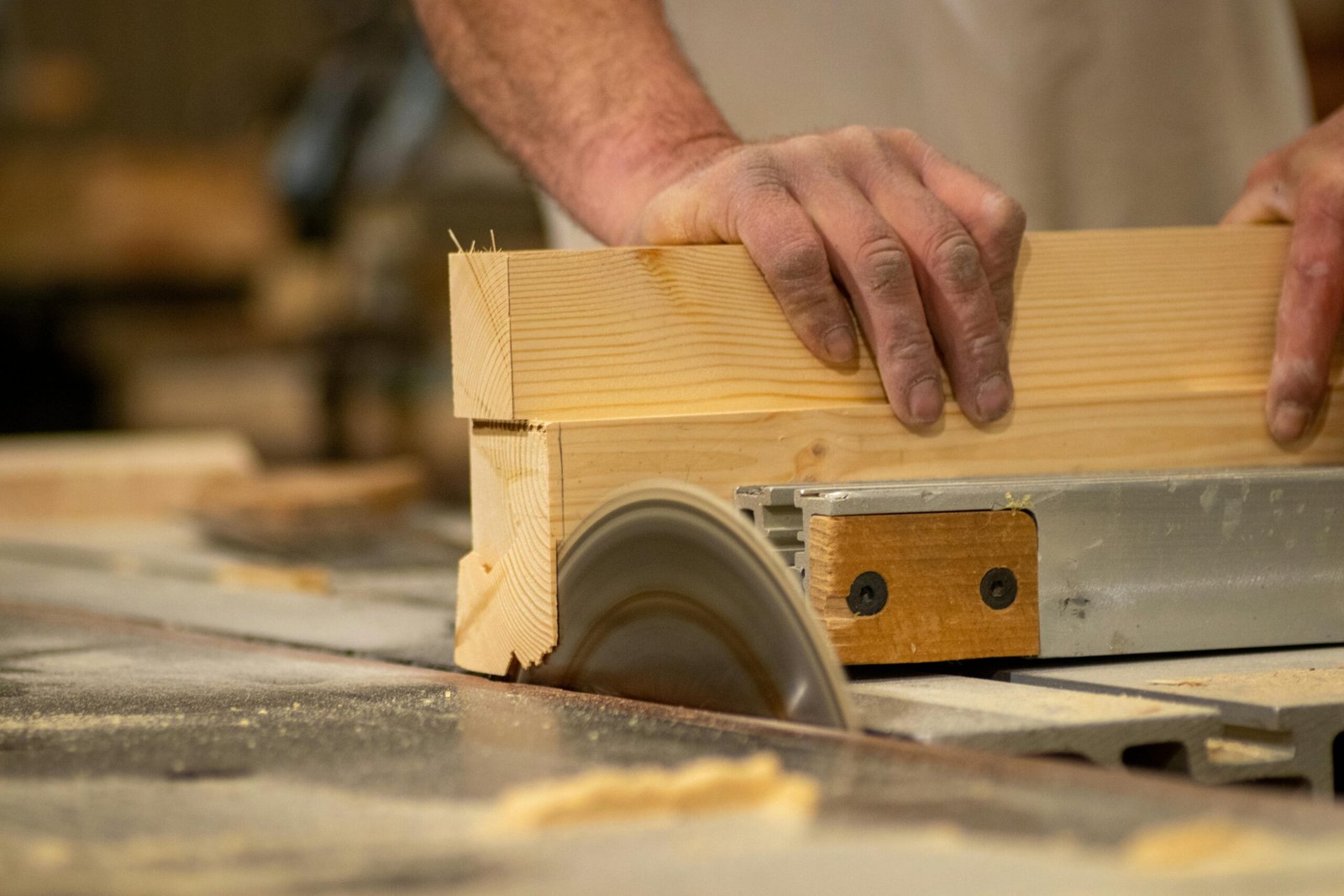 Close-up of a craftsman using a saw, showcasing woodworking skill and precision.
